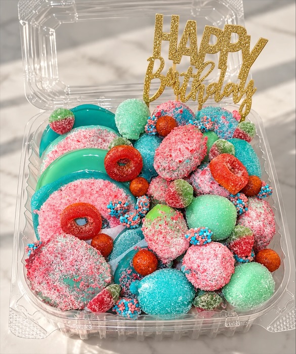 A teal and pink birthday tray with a gold Happy Birthday topper